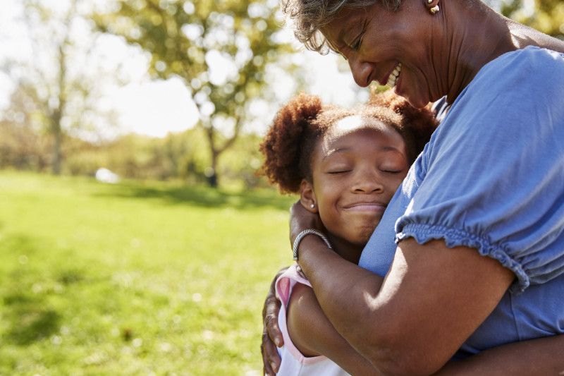 Women hugging a child.