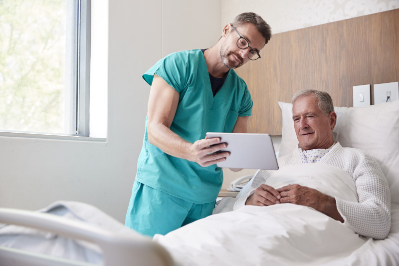 A nurse showing a patient a tablet.