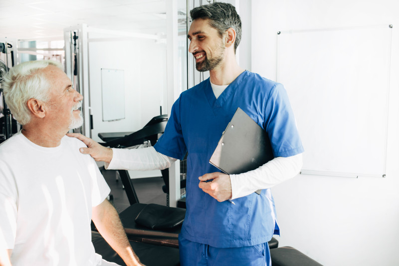 Nurse with his hand on a residents shoulder.
