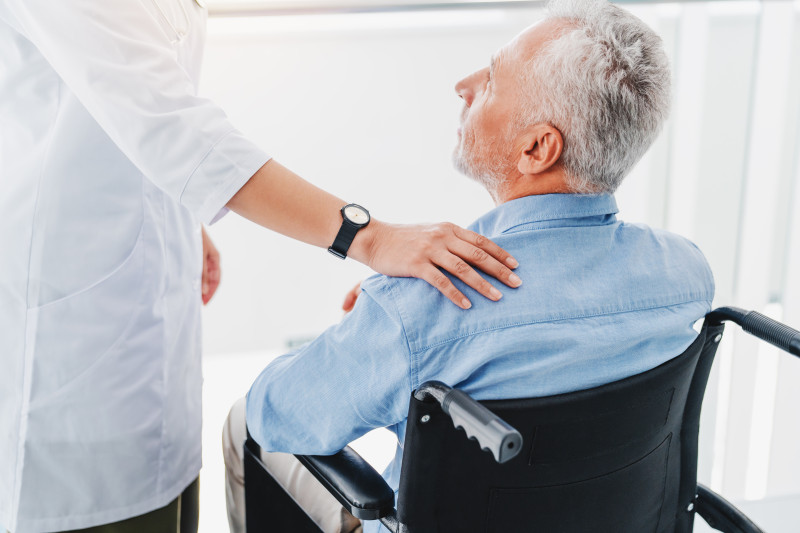 Nurse with their hand on a residents shoulder.