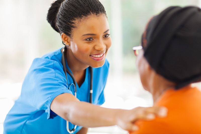Nurse with her hand on a residents shoulder.