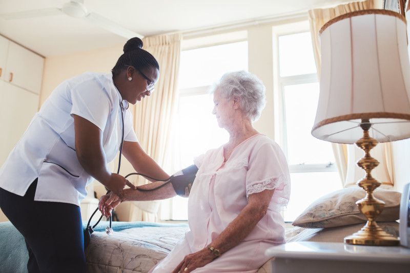 Nurse taking a residents blood pressure.