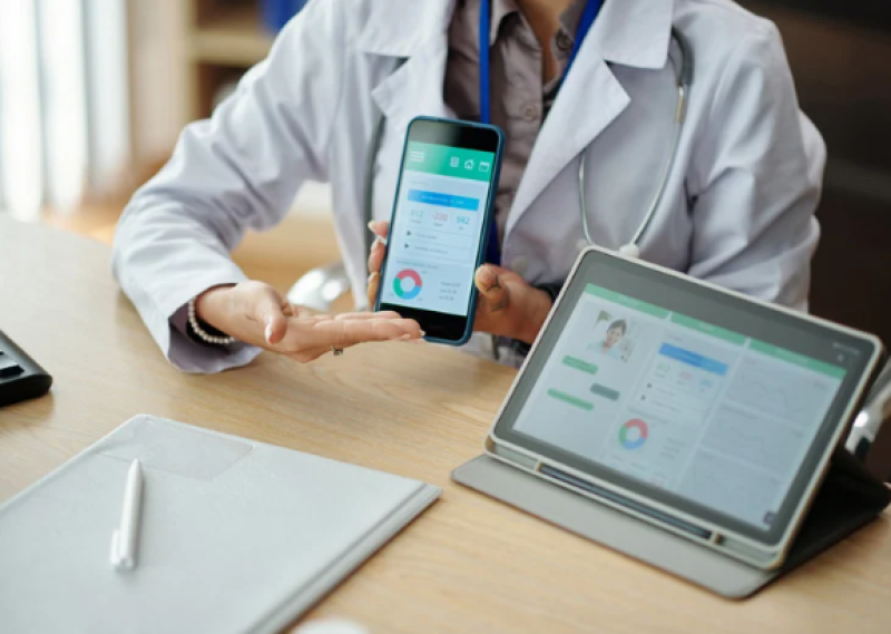 Doctor showing a patient their remote monitoring on different devices.