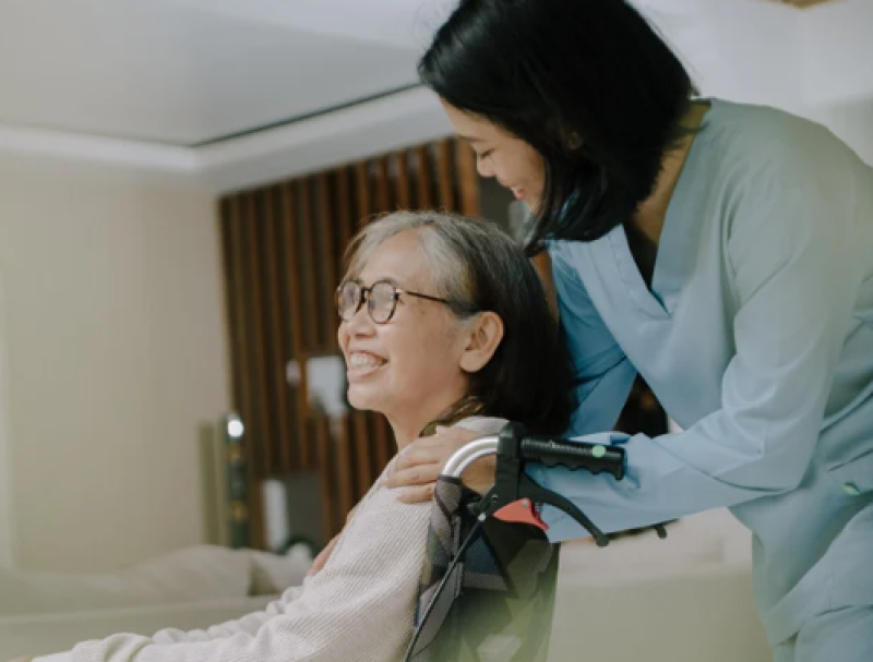 Nurse with their hand on a residents shoulder.